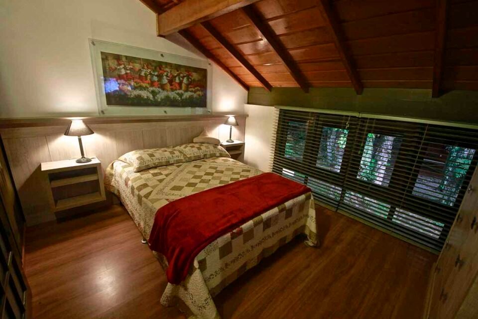 Suíte 3 da casa principal com cama de casal sob o teto de madeira